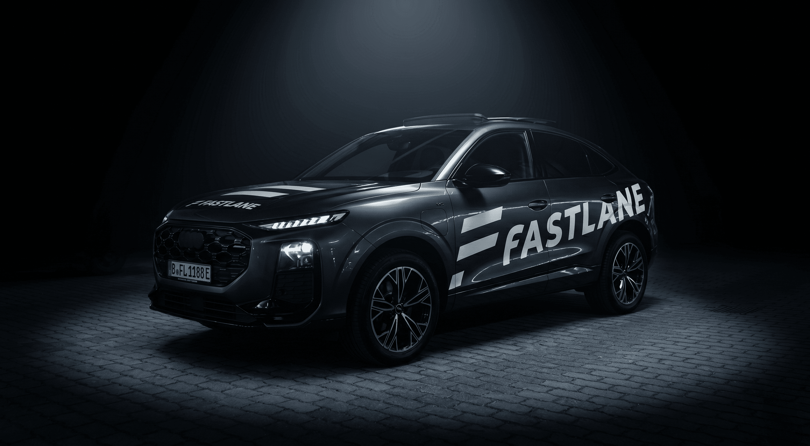 Audi Q3 Sportback der Fahrschule Fastlane im Scheinwerferlicht